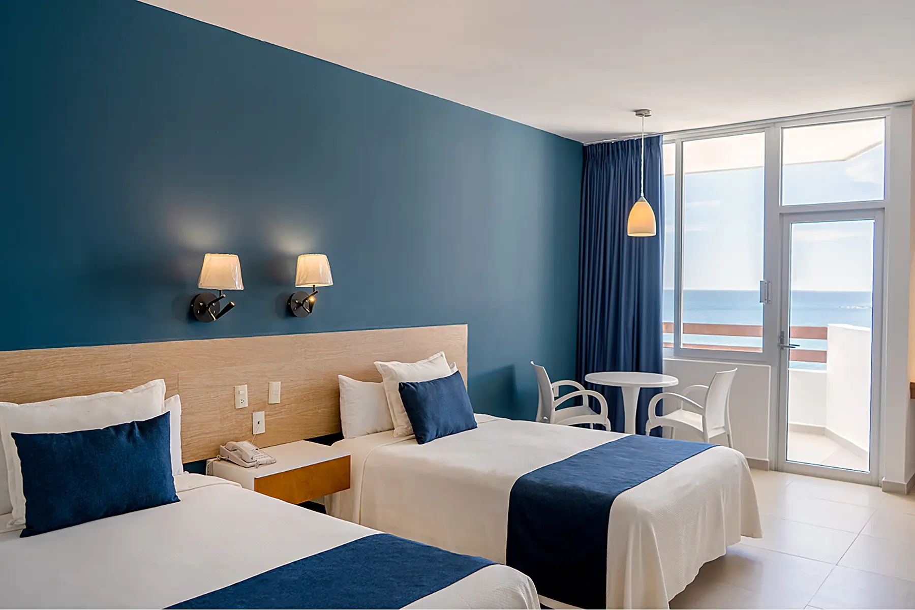 Standard room with balcony and sea view, two double beds, table with two chairs at the Oceano Palace Mazatlán hotel